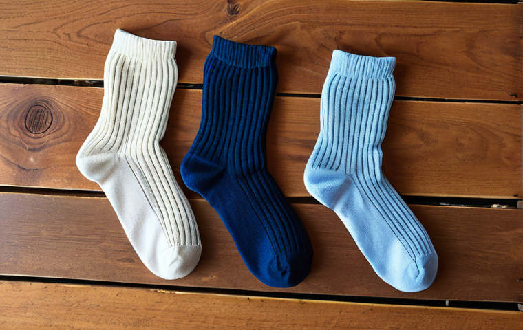 **
A close-up photo of three different types of socks (cotton, synthetic, Merino wool) laid out side-by-side. Each sock should have a label clearly indicating its material. The background should be simple, perhaps a wooden surface, to focus attention on the socks. The lighting should be bright and even to show the texture of each material. The scene should visually communicate the differences in texture and appearance between the sock types.
**